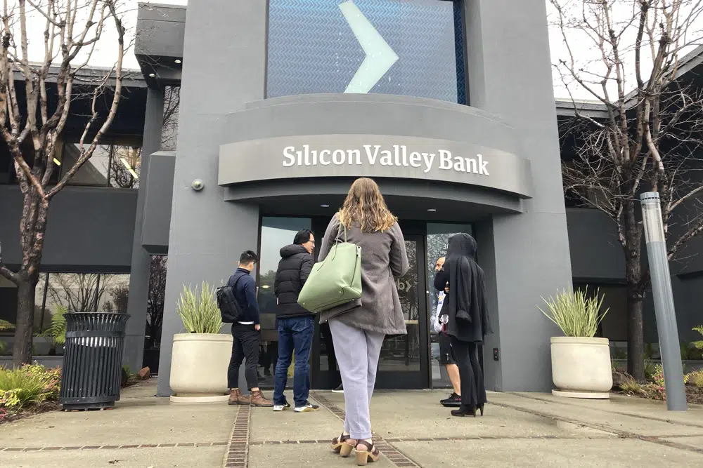 People stand outside of an entrance to Silicon Valley Bank in Santa Clara